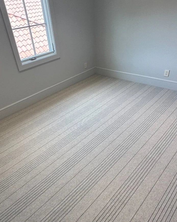 Professional bedroom carpet installation in New York with premium neutral striped carpet for a modern interior.