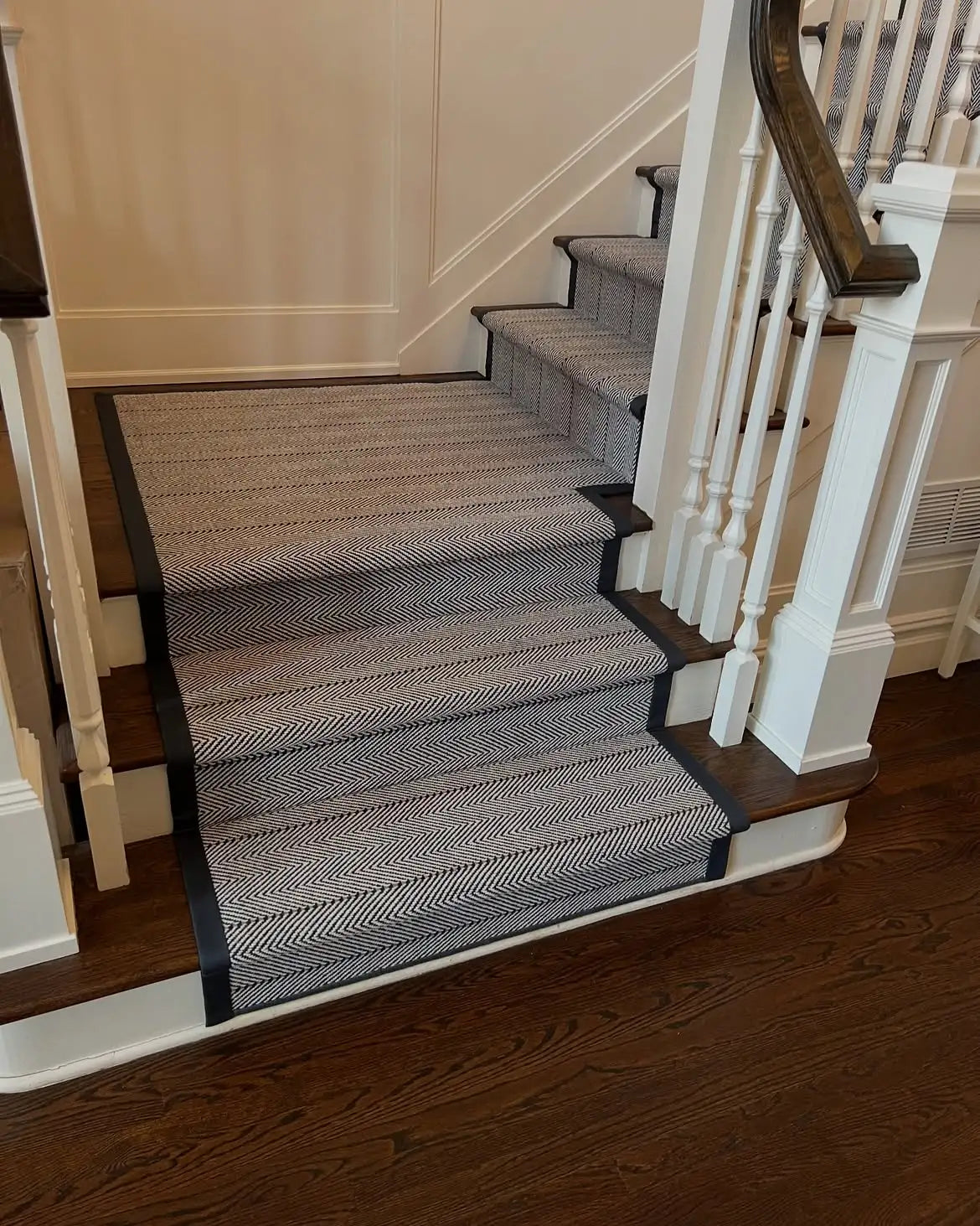 Herringbone custom stair runner with black border installed on hardwood stairs in Brooklyn, NYC.