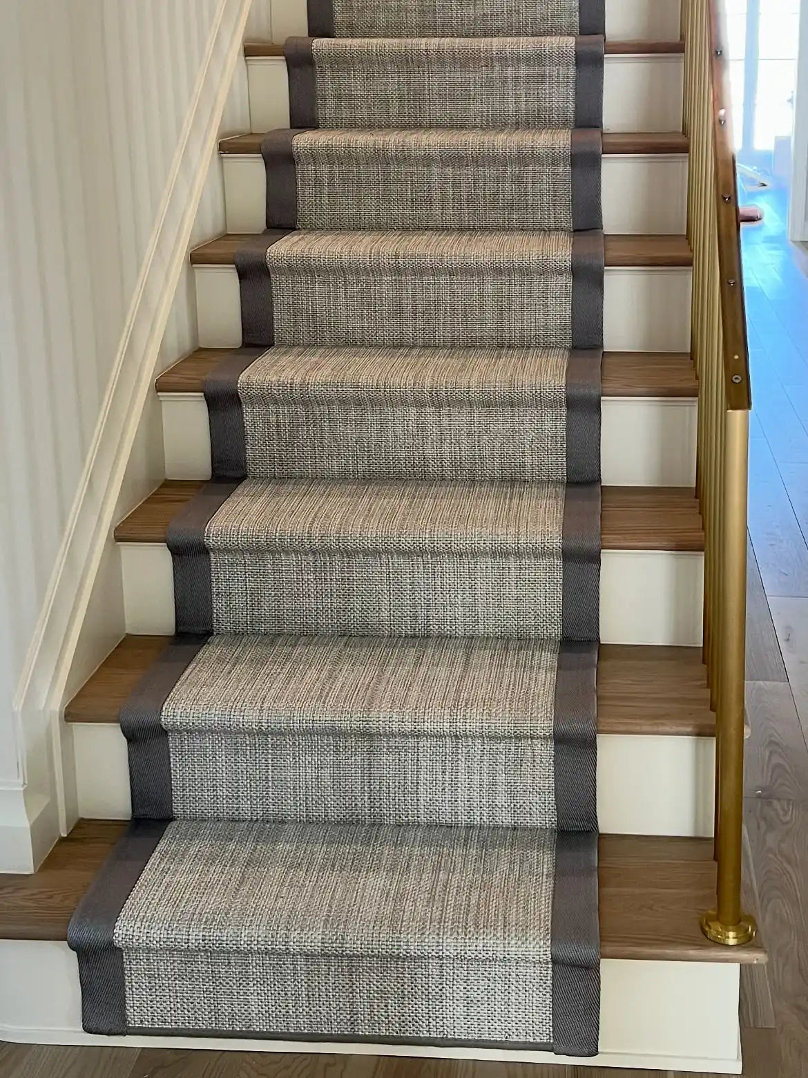 Luxury gray woven stair runner with decorative border installed on a hardwood staircase in Brooklyn, NYC.