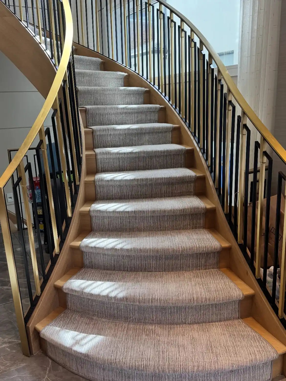 Modern custom stair runner installed on a curved staircase in a luxury New York City home.