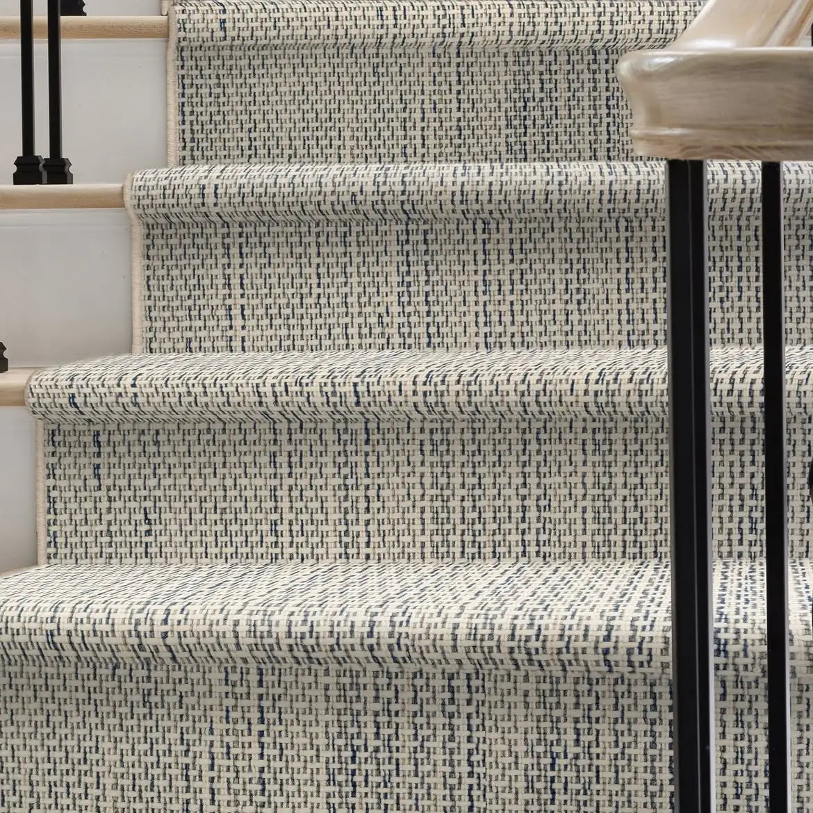 Patterned custom stair runner installed on a curved staircase.