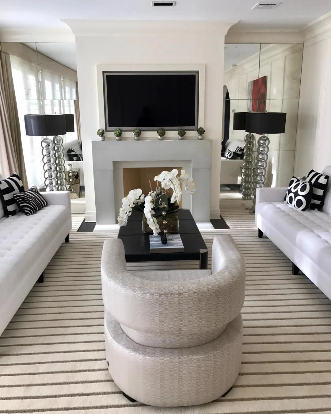 Modern living room featuring a custom cream striped area rug with white sofas, fireplace, and contemporary furniture.
